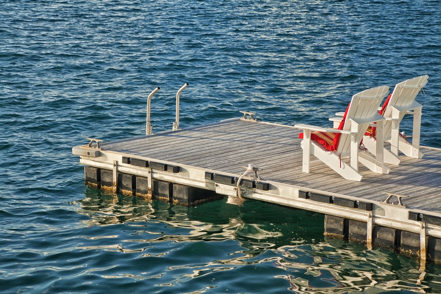 2 Sessel auf einem Holzsteg über dem Wasser